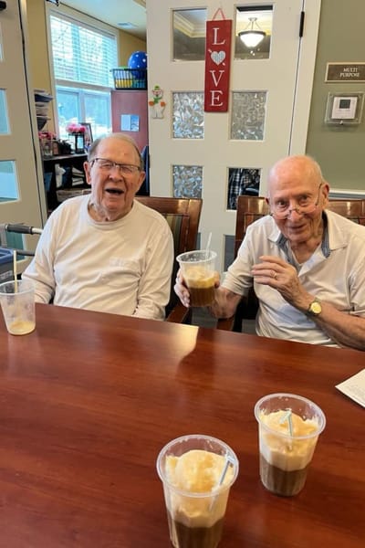 Two residents enjoying drinks at a communal table