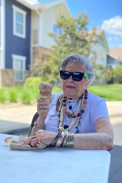 Resident enjoying ice cream outdoors in a vibrant setting