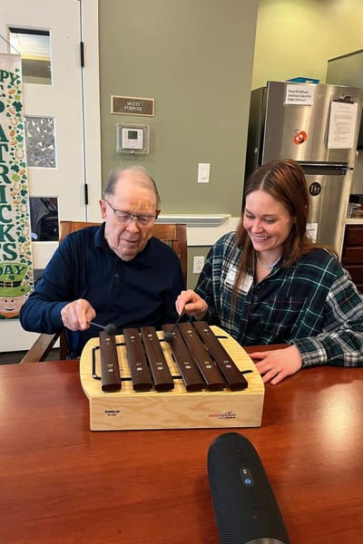 Resident and staff member playing music together