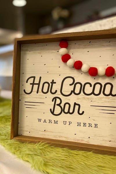 Sign for a hot cocoa bar in a cozy setting