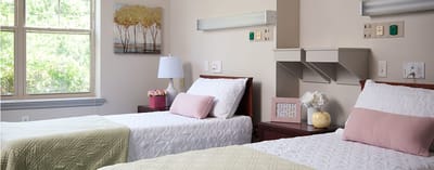 Two beds in a cozy resident room with natural light