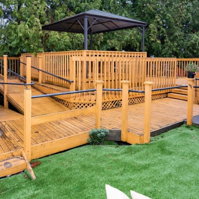Wooden outdoor deck with gazebo and greenery