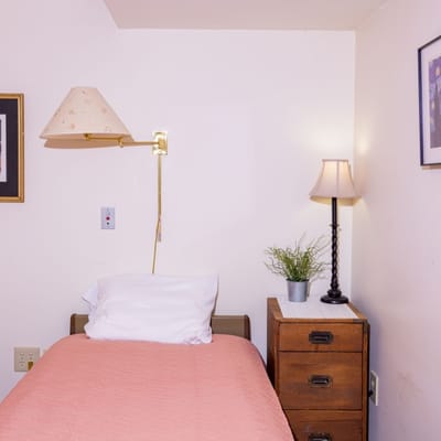 Cozy resident room with bed and lamp