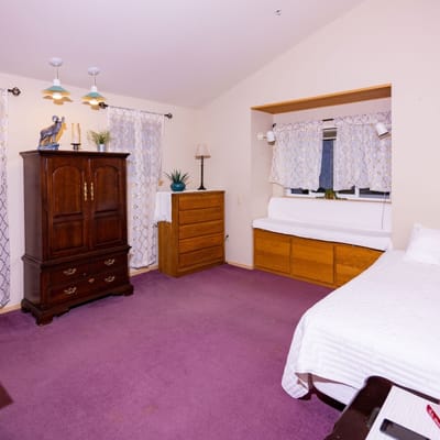 Brightly lit private resident room with furnishings