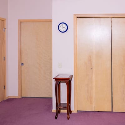 Plain interior hallway with wooden doors and a clock