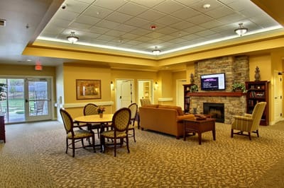 Common area of a senior living facility with seating and fireplace