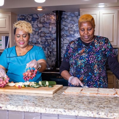 Two staff members preparing food in the kitchen