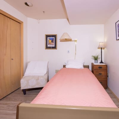 A well-furnished resident room with a single bed.