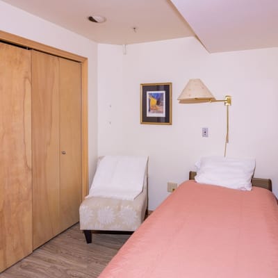 Private resident room with a bed and chair