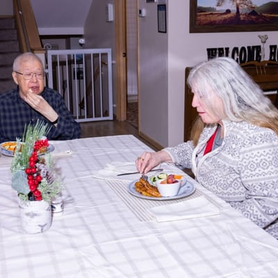 Two residents enjoying a meal in a cozy dining area