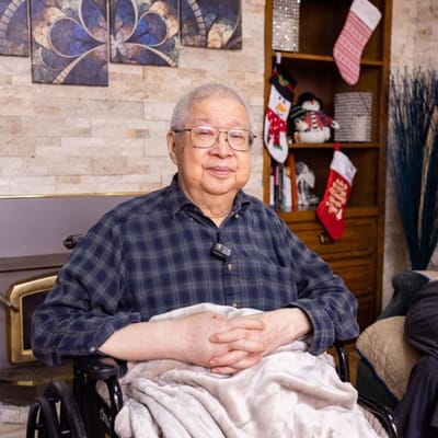 Resident in wheelchair with a blanket in a cozy interior