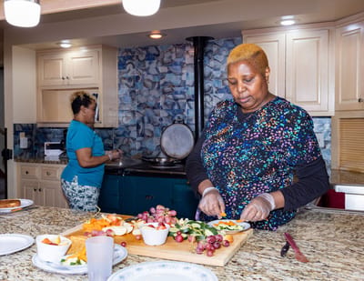 Staff preparing fresh fruits in a kitchen area