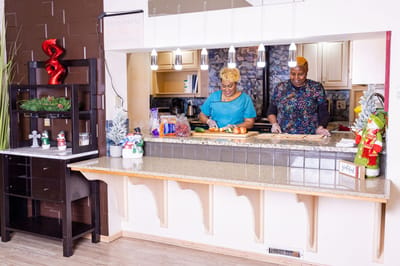 Two staff members preparing food in a welcoming kitchen