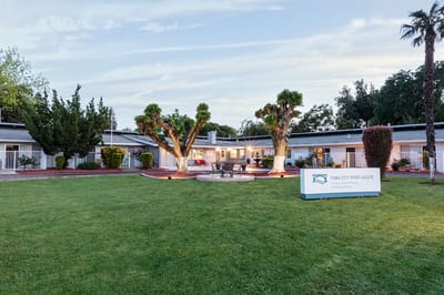 Exterior view of Yuba City Post-Acute facility with lawn and trees