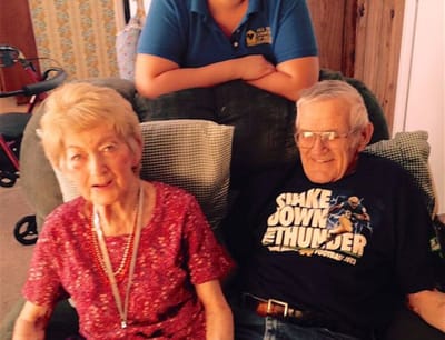 Two elderly residents sitting with a caregiver