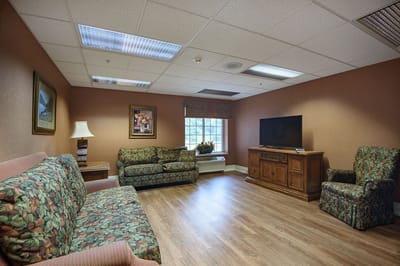 Cozy lounge area with floral sofas and a TV