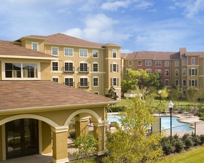 Exterior view of the facility with gardens and pool