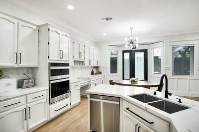 Modern kitchen space with white cabinets and dining table