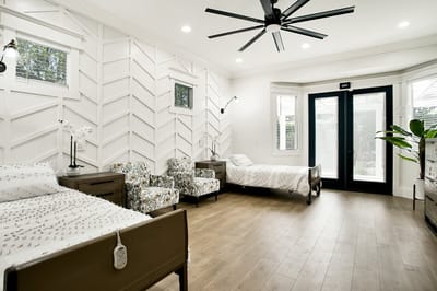 Bright interior room with twin beds and patterned chairs