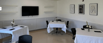 Minimalist dining area with tables and art