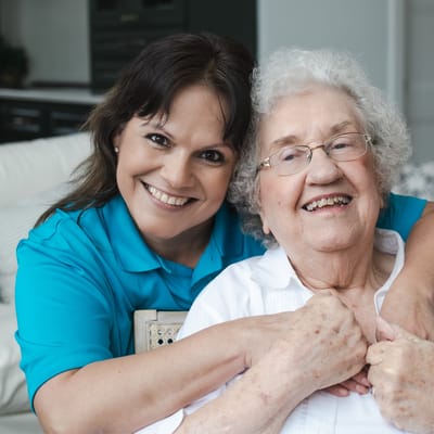 Caregiver embracing a smiling resident in a cozy setting