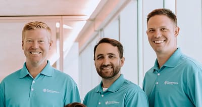 Staff members pose in a bright facility lobby