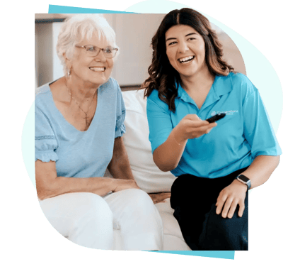 A resident and caregiver sharing a joyful moment indoors