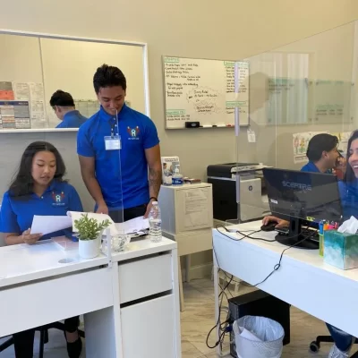 Staff assisting residents at their desks.
