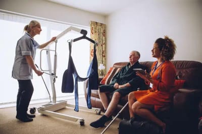Care staff assisting a resident with mobility equipment.