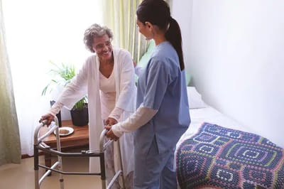 Nurse assisting an elderly woman in her room.
