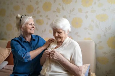 Caregiver assisting a senior woman indoors
