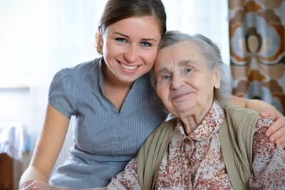 Caregiver and resident smiling together indoors