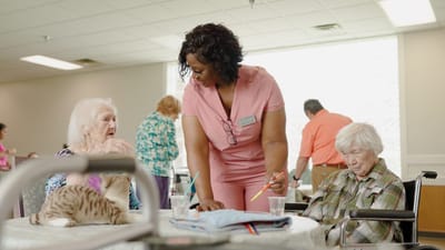 Residents engaging in activities with staff support.