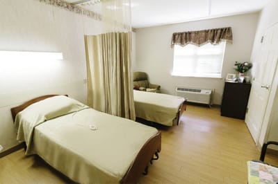Clean shared resident room with beds and furniture