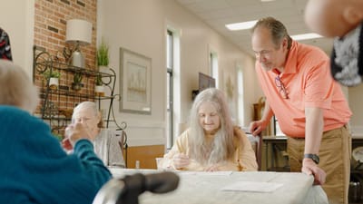 Residents engaging in an activity with staff assistance.