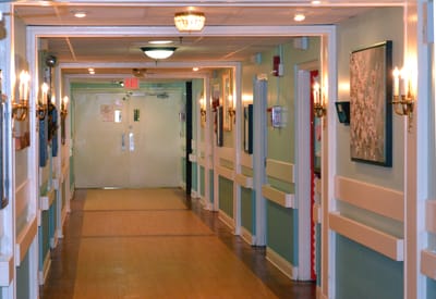 Interior hallway with wall sconces and artwork