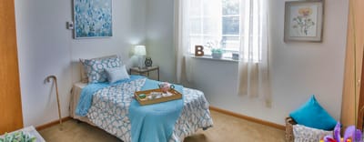 A well-decorated private resident room with a bed and artwork