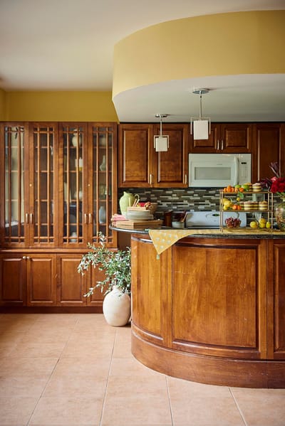 Interior kitchen area with wooden cabinets and fruit display