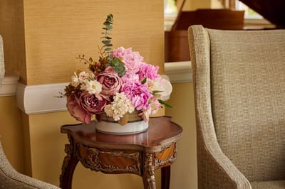 Brandywine The Savoy, assisted living in Queens, NY — Floral arrangement on a decorative table near a chair