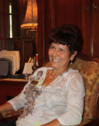 A smiling resident sitting in a cozy interior space