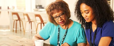 Resident and staff member engaged at a table