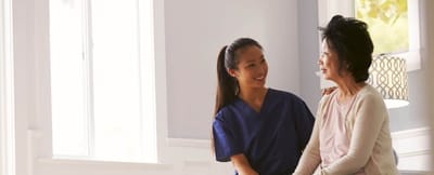 Caregiver talking with resident in bright room