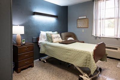 A well-furnished resident room with a hospital bed