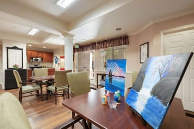Bright activity room with art supplies and paintings