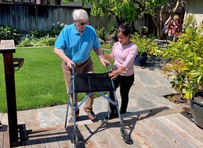 Caregiver assisting a resident in an outdoor garden