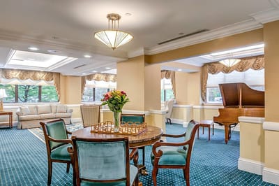 Bright common area with seating and a piano