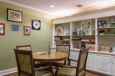 Brightly decorated activity room with a table and art supplies