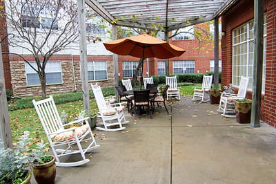 Outdoor seating area with rocking chairs and umbrella