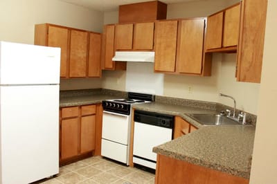 Bright kitchen area with wooden cabinets and appliances