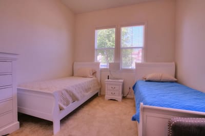 Brightly lit interior of a resident room with two beds